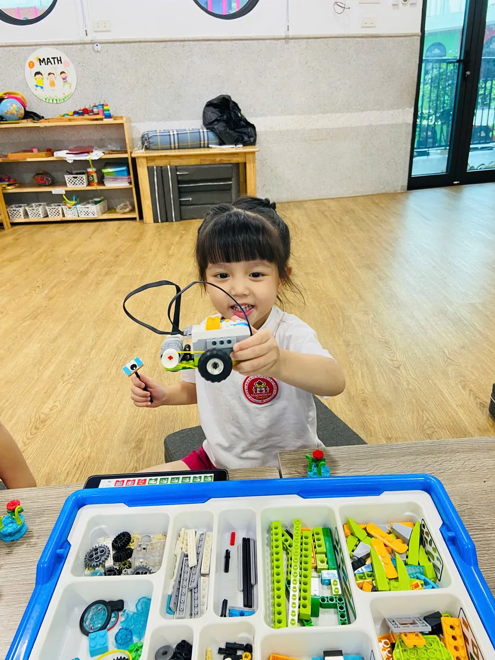 Học sinh Maple Bear giơ cao mô hình robot LEGO WeDo do chính em lắp ráp trong giờ học STEM
