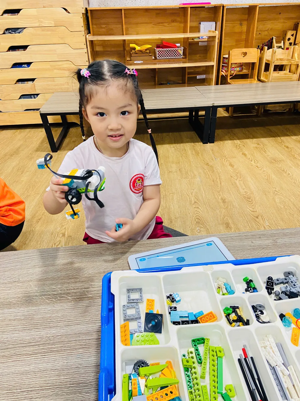 Học sinh cầm mô hình robot LEGO WeDo đã lắp ráp xong, chuẩn bị trình bày trước lớp