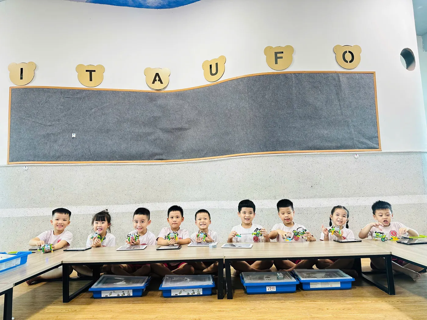 Toàn cảnh lớp học STEM tại Trường Mầm non Quốc tế Maple Bear Arita UFO: học sinh ngồi thành hàng, mỗi em một mô hình robot LEGO WeDo hoàn chỉnh trước mặt
